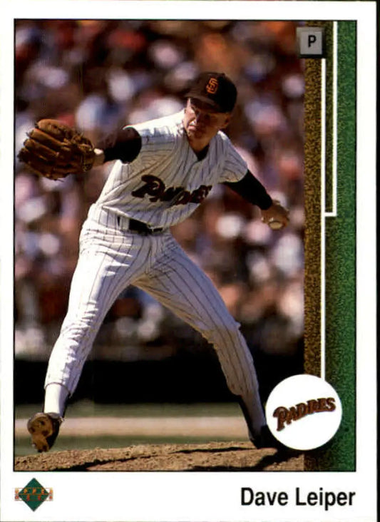 Baseball pitcher in San Diego Padres pinstriped uniform mid-delivery action shot