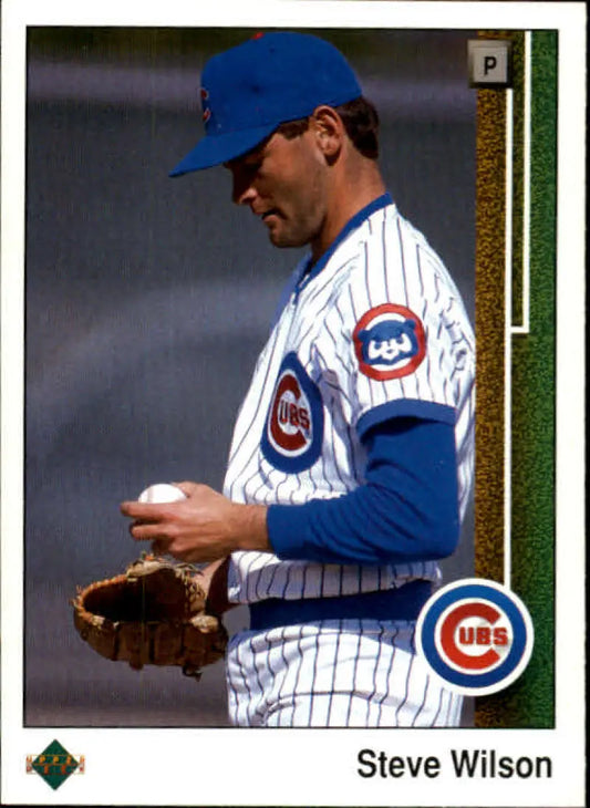 Baseball player in Chicago Cubs uniform examining a baseball on Upper Deck card