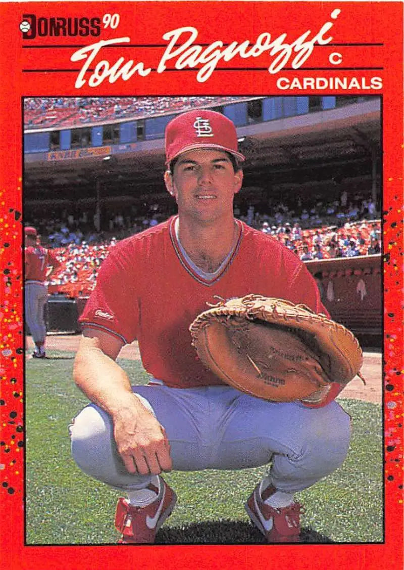 Red 1990 Donruss Tom Pagnozzi baseball card featuring a Cardinals catcher in action