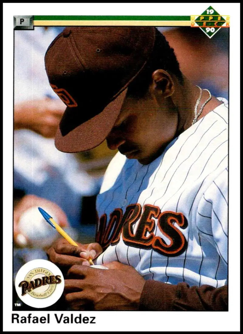 Rafael Valdez signing an autograph in a San Diego Padres uniform