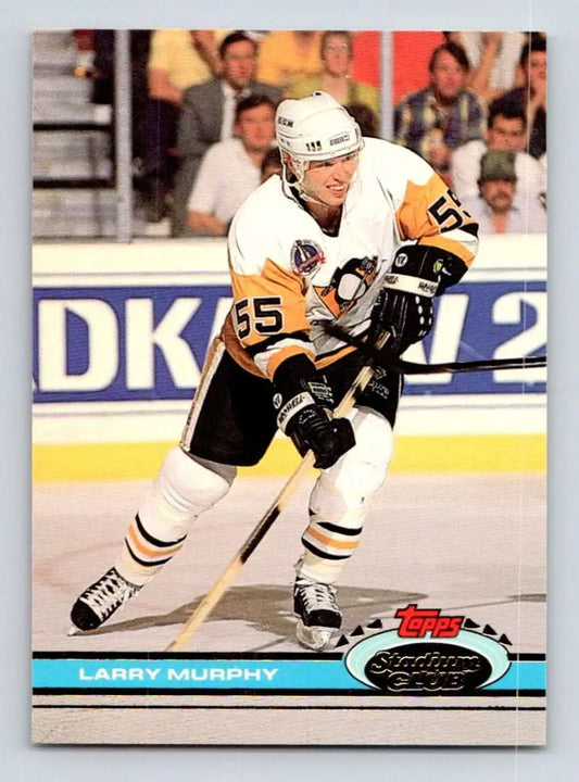 Hockey player in white Pittsburgh Penguins jersey skates, showcasing Larry Murphy Topps Stadium Club card