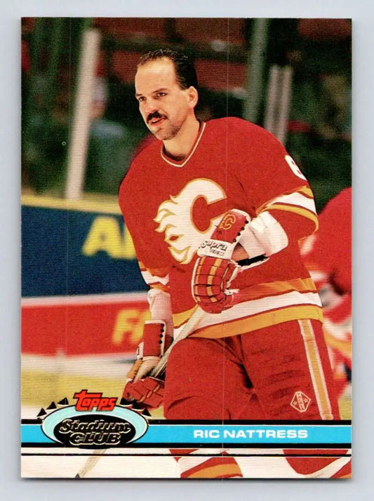 Hockey player in red Calgary Flames jersey showcasing Ric Nattress Topps Stadium Club card