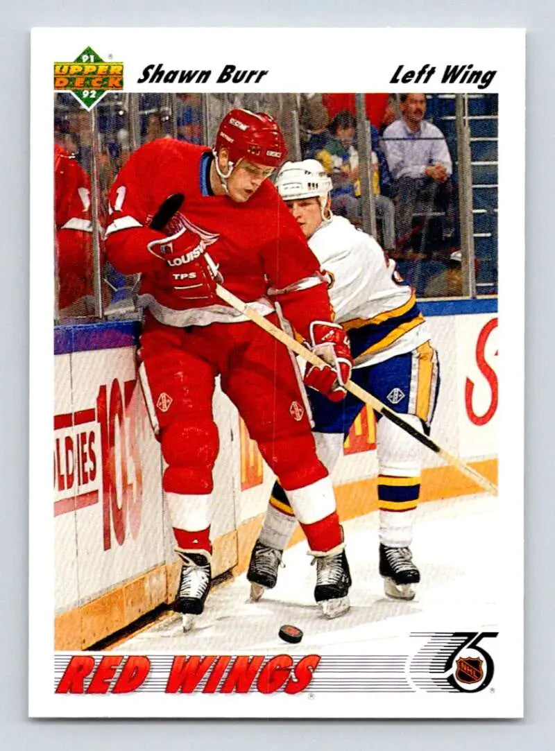 Hockey player in Detroit Red Wings jersey battles for puck in action shot