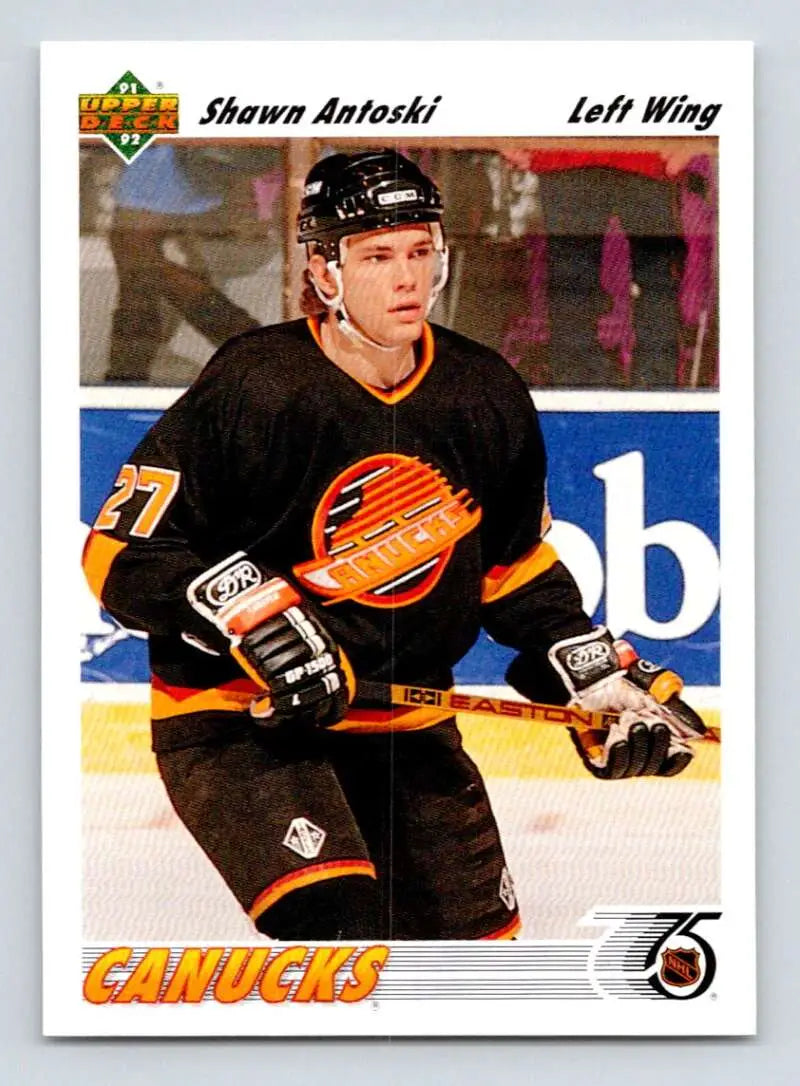 Hockey player in black Vancouver Canucks jersey showcasing Shawn Antoski Upper Deck card