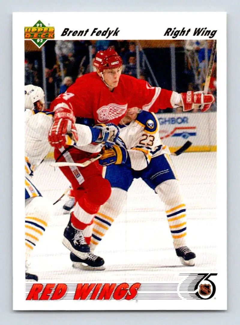 Hockey player in Detroit Red Wings jersey competes against opponent in blue and yellow uniform