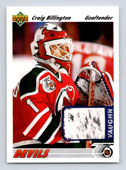 Hockey goalie in red and black jersey wearing white mask, showcasing Craig Billington