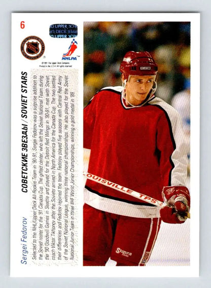 Hockey player in red jersey with stick, featured on Detroit Red Wings hockey card