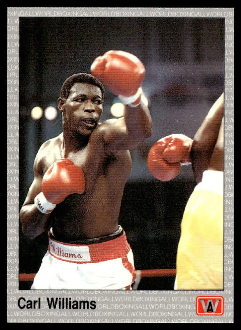 Boxer Carl Williams in white shorts and red gloves throwing a punch during match