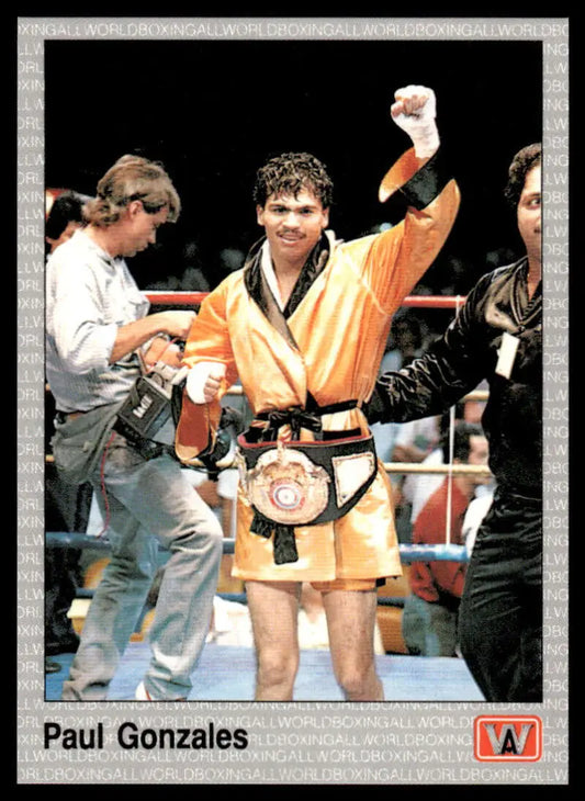 Paul Gonzales celebrates with a championship belt in his orange robe, boxing card image