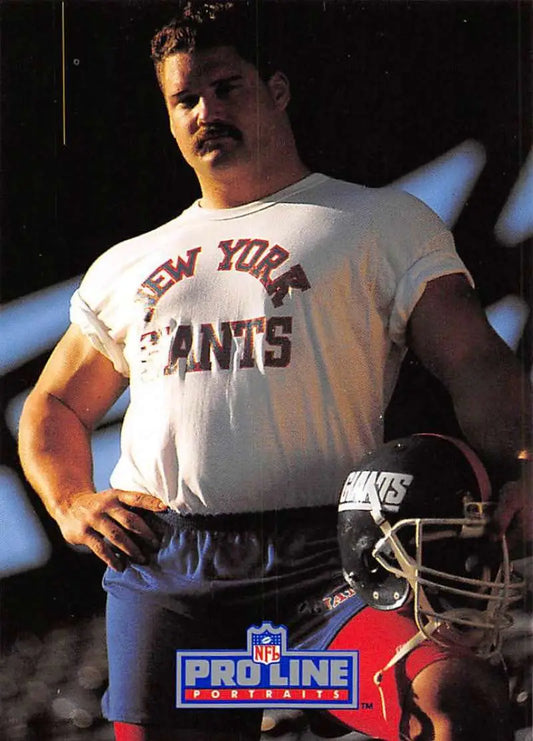 Football player in New York Giants t-shirt beside Giants helmet for Erik Howard card