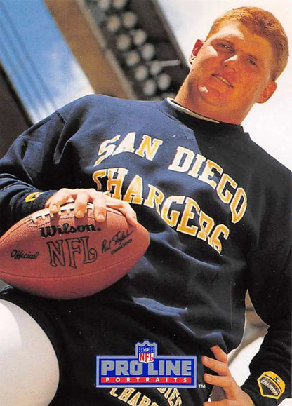 Person in San Diego Chargers sweatshirt holding NFL football, showcasing team spirit