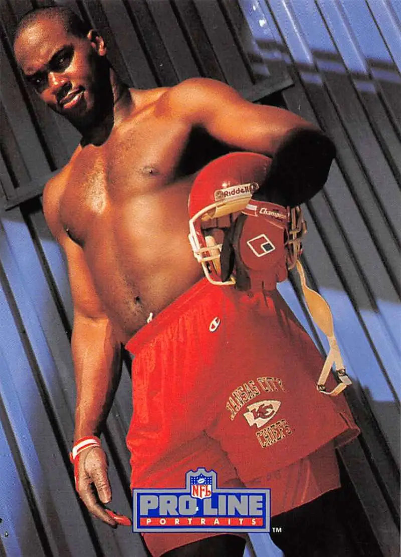 Shirtless athlete with sunglasses holding Kansas City Chiefs Derrick Thomas football jersey