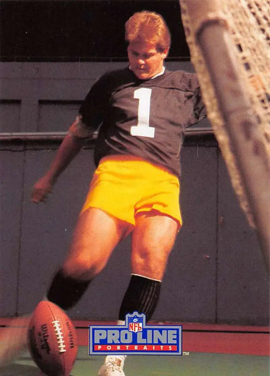 Football player in black jersey and yellow shorts kicking football for Pittsburgh Steelers