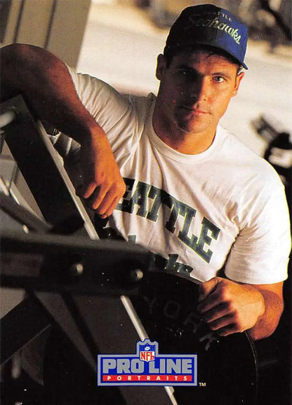 Football player in white Seattle t-shirt and blue cap for David Wyman football card