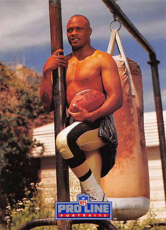 Eric Martin poses with a football on exercise equipment for Orleans Saints football card