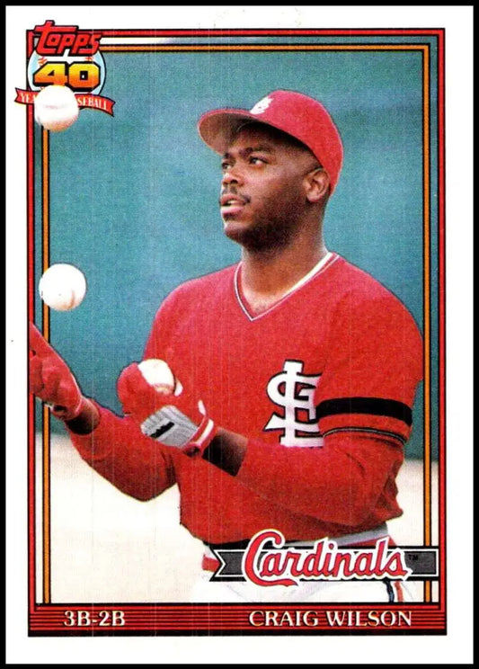 Baseball card of Craig Wilson juggling baseballs in red uniform for St. Louis Cardinals