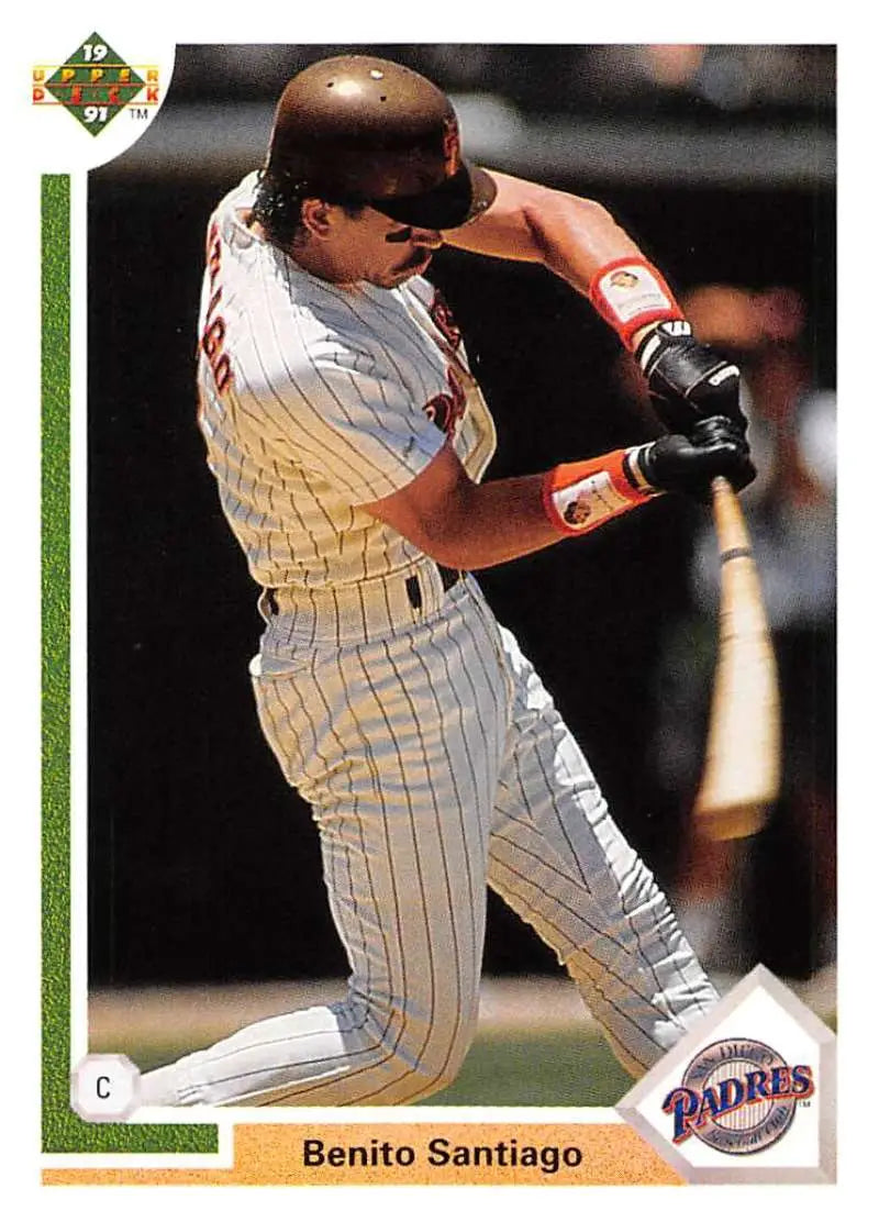 Baseball player in San Diego Padres pinstripe uniform swinging bat featuring Benito Santiago