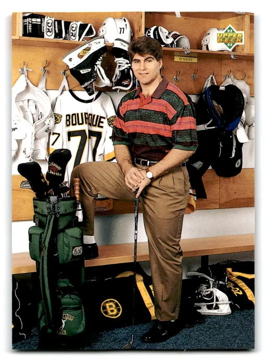 Man in locker room with golf clubs next to Ray Bourque Upper Deck trading cards