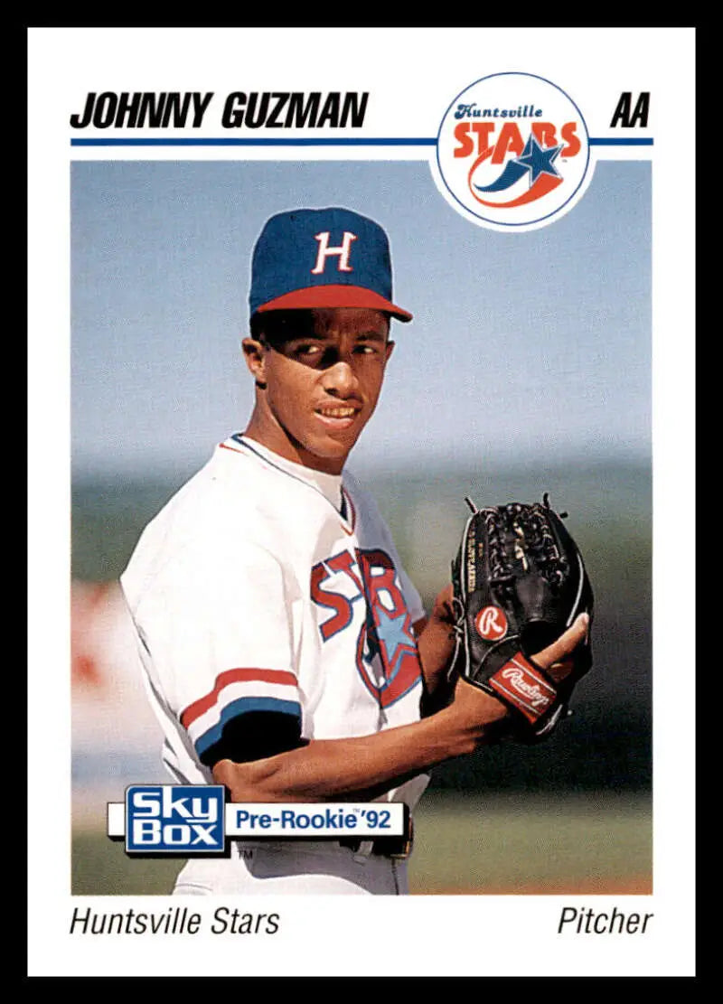 Baseball card of Johnny Guzman in white uniform with blue H cap for Huntsville Stars