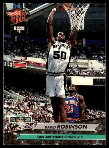 David Robinson in white Spurs jersey dunking over defender in blue uniform during game