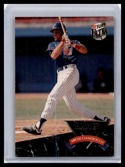 Baseball player in pinstriped uniform swinging bat for Montreal Expos baseball card