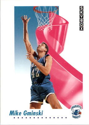 Mike Gminski in blue uniform reaching for hoop, backdrop features pink ribbon