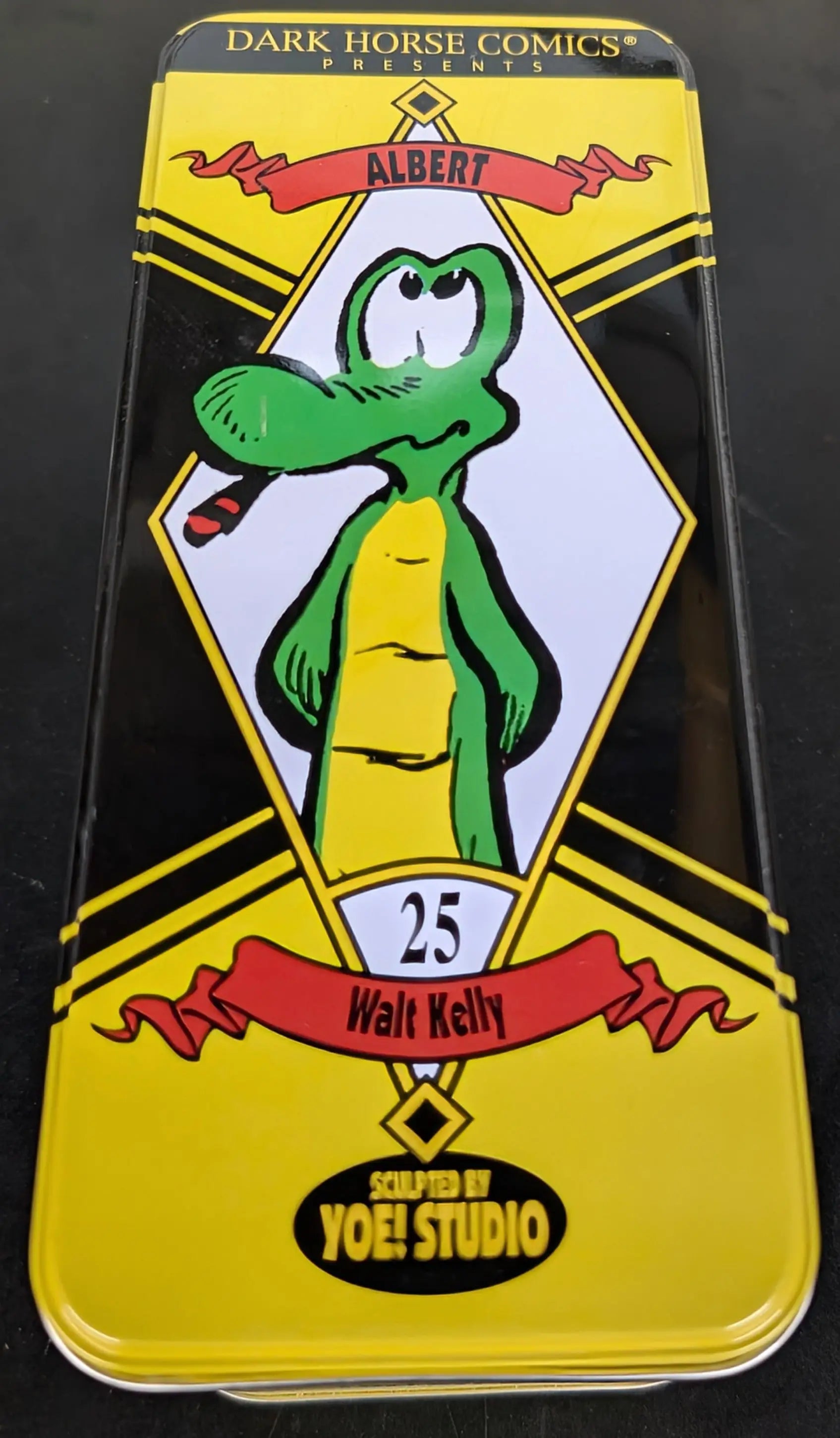 Green cartoon alligator character pin for 2001 Dark Horse Albert in a vintage-style tin box