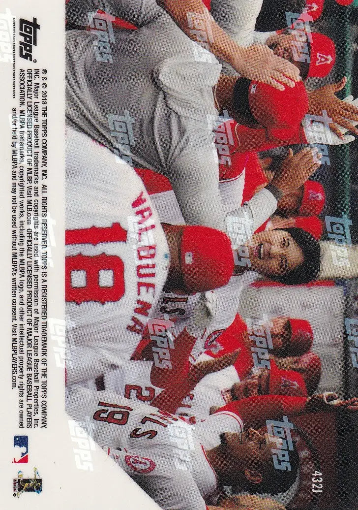 Baseball players in Los Angeles Angels uniforms celebrate Shohei Ohtani’s success in dugout