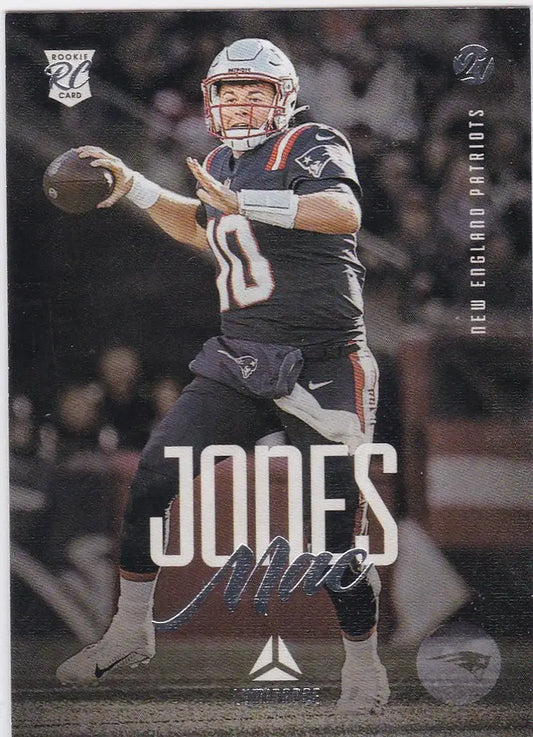 Football player in dark uniform throwing pass from Panini Chronicles Luminance Mac Jones card