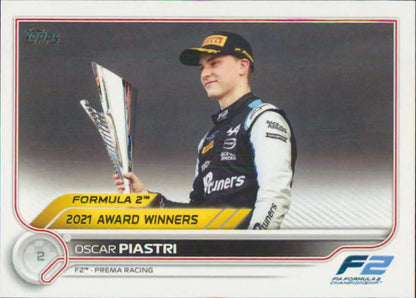 Oscar Piastri holding a trophy in a white suit, featured in Topps Formula 1 card collection