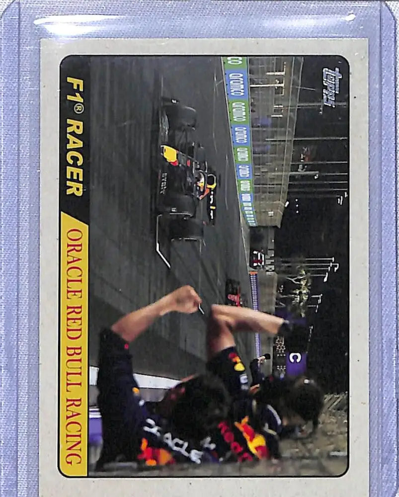 Motorcycle racer sliding on track with 2022 Topps Formula 1 RB18 Max Verstappen card