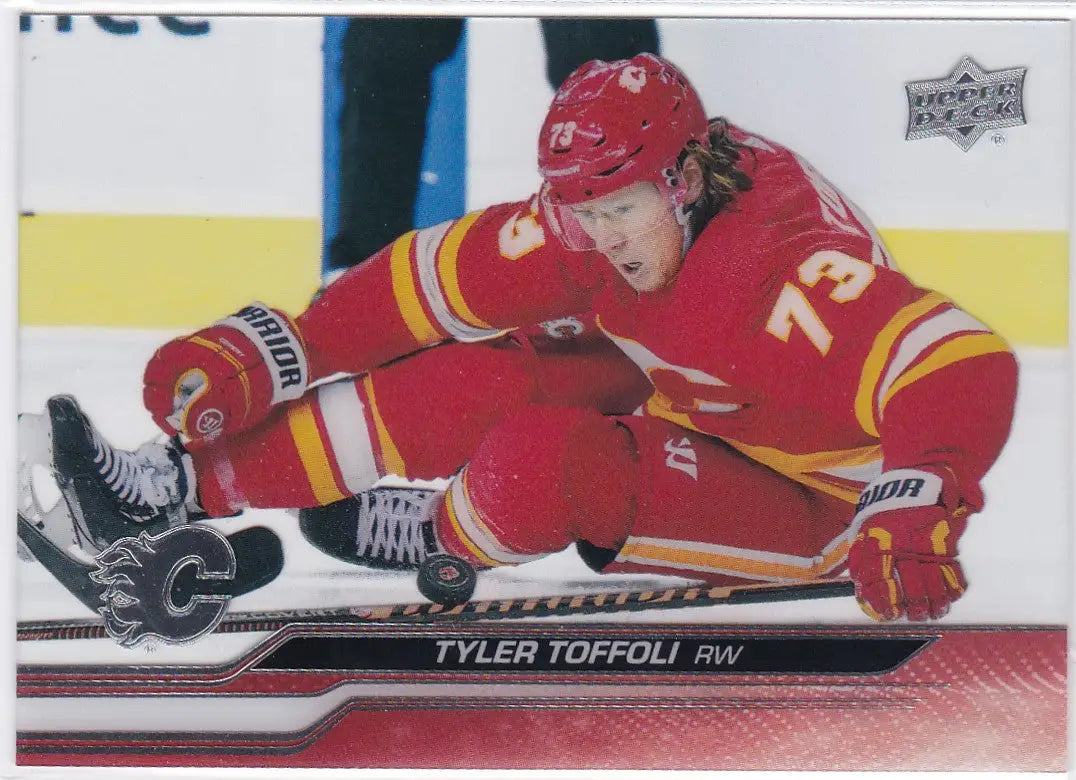 Ice hockey player in red jersey lunging on ice; Tyler Toffoli Clear Calgary Flames