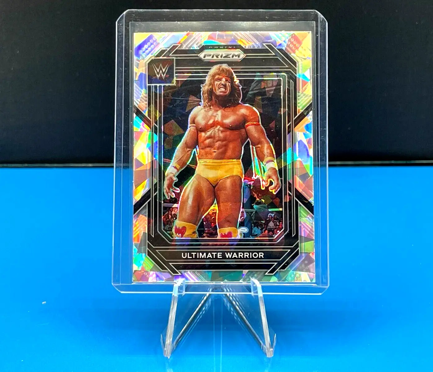 Holographic Ultimate Warrior Silver Cracked Ice WWE trading card on a clear stand