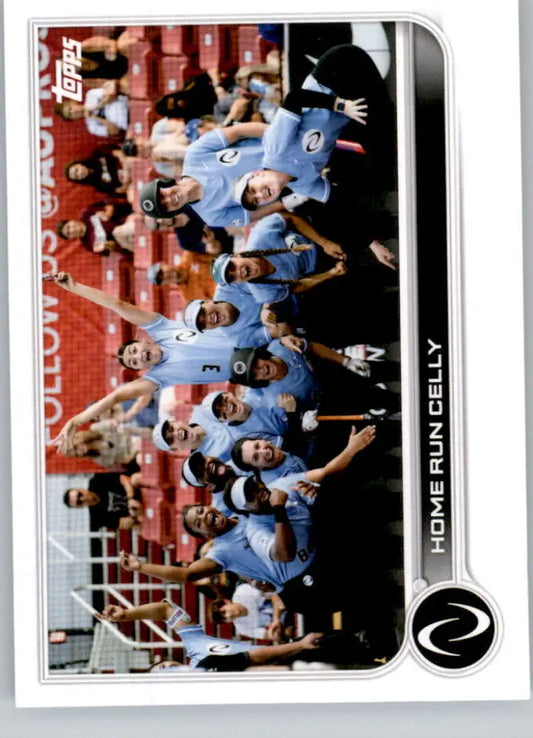 Baseball team in light blue uniforms sitting in dugout for Topps Athletes Unlimited Home Run Celly Softball