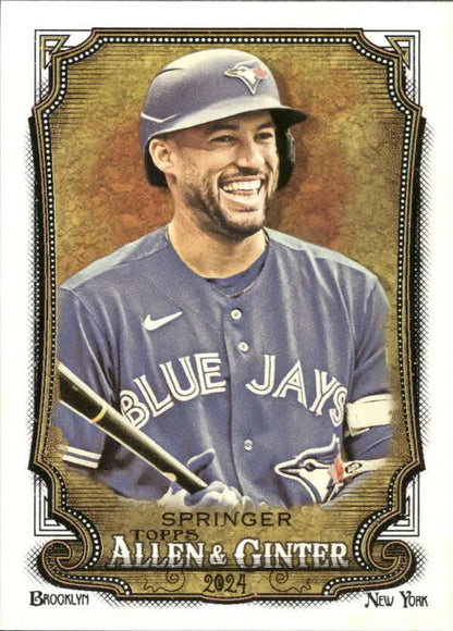 George Springer smiles holding a bat in his Toronto Blue Jays uniform for 2024 card