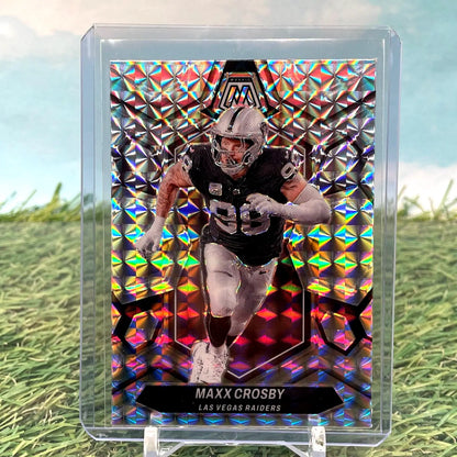 Mosaic Prizm football card of Maxx Crosby in black uniform running with the ball