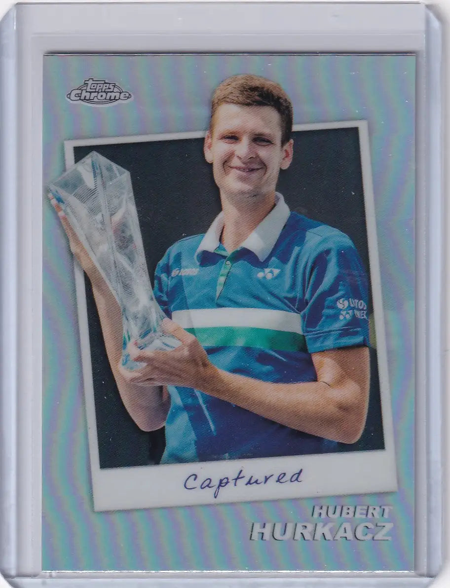 Trading card of Hubert Hurkacz in blue polo holding trophy from Topps Chrome Captured