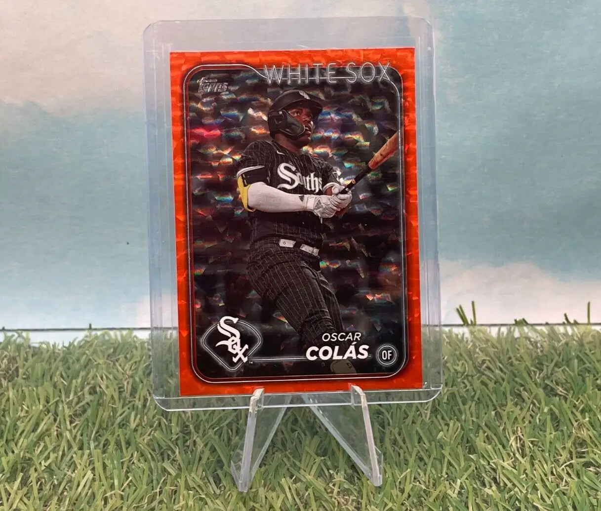 Oscar Colas baseball card from 2024 Topps Series 1 White Sox Orange Foil 021/299