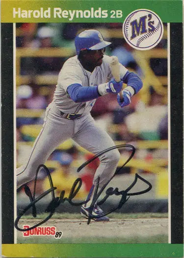 Autographed base card of Harold Reynolds in white and blue uniform preparing to bunt