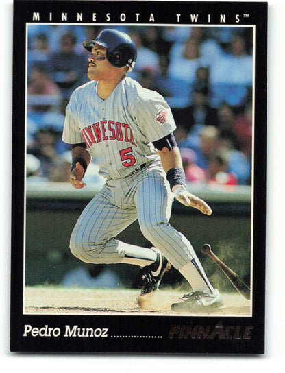 Baseball player Pedro Munoz in Minnesota Twins pinstriped uniform swinging bat