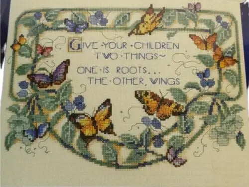 Cross-stitched inspirational quote with butterfly, floral border from Leisure Arts Designs