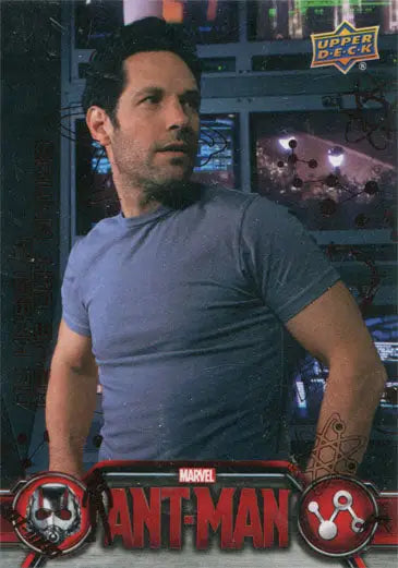 Man in light blue t-shirt with serious expression holding Marvel Ant-Man Bronze Base Parallel Chase Card