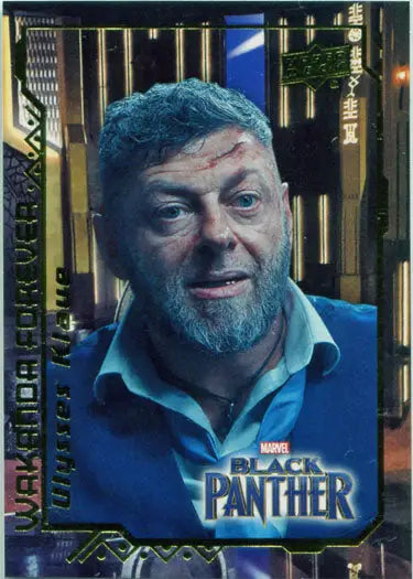 Middle-aged man with blue hair and beard in blue shirt as Andy Serkis in Marvel Black Panther