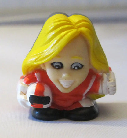 Small plastic figurine of a smiling character from NFL TeenyFreaks series with bright yellow hair