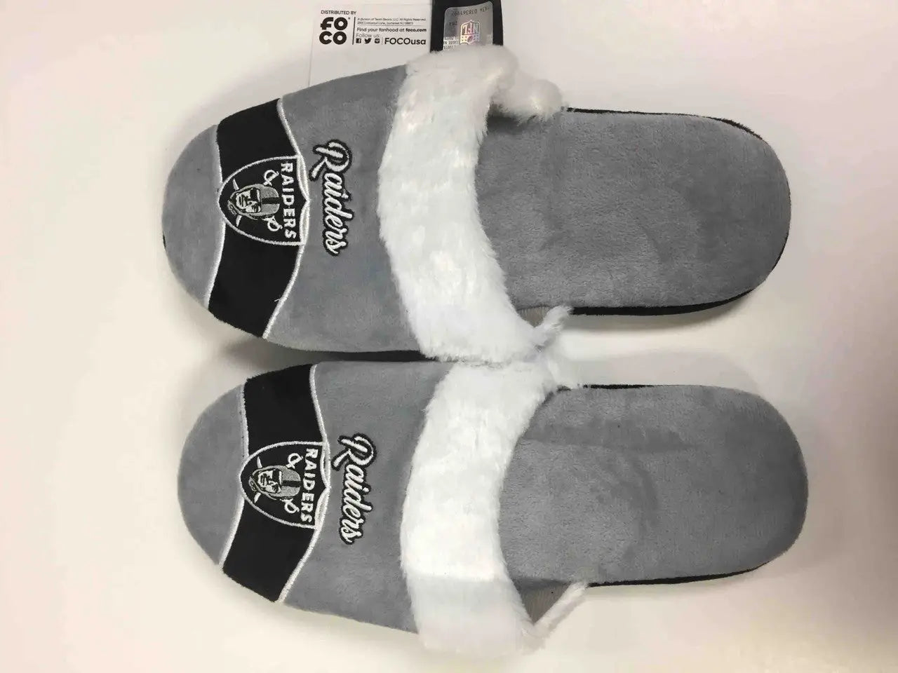 Gray and black Raiders brand womens stripe logo slippers with white faux fur straps