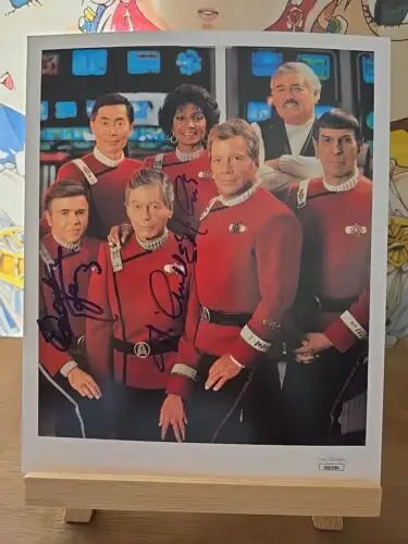 Star Trek movie cast photo featuring Nichelle Nichols and Walter Koenig in red uniforms