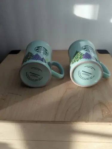 Two light blue Starbucks mugs from the Holiday Christmas Collection set